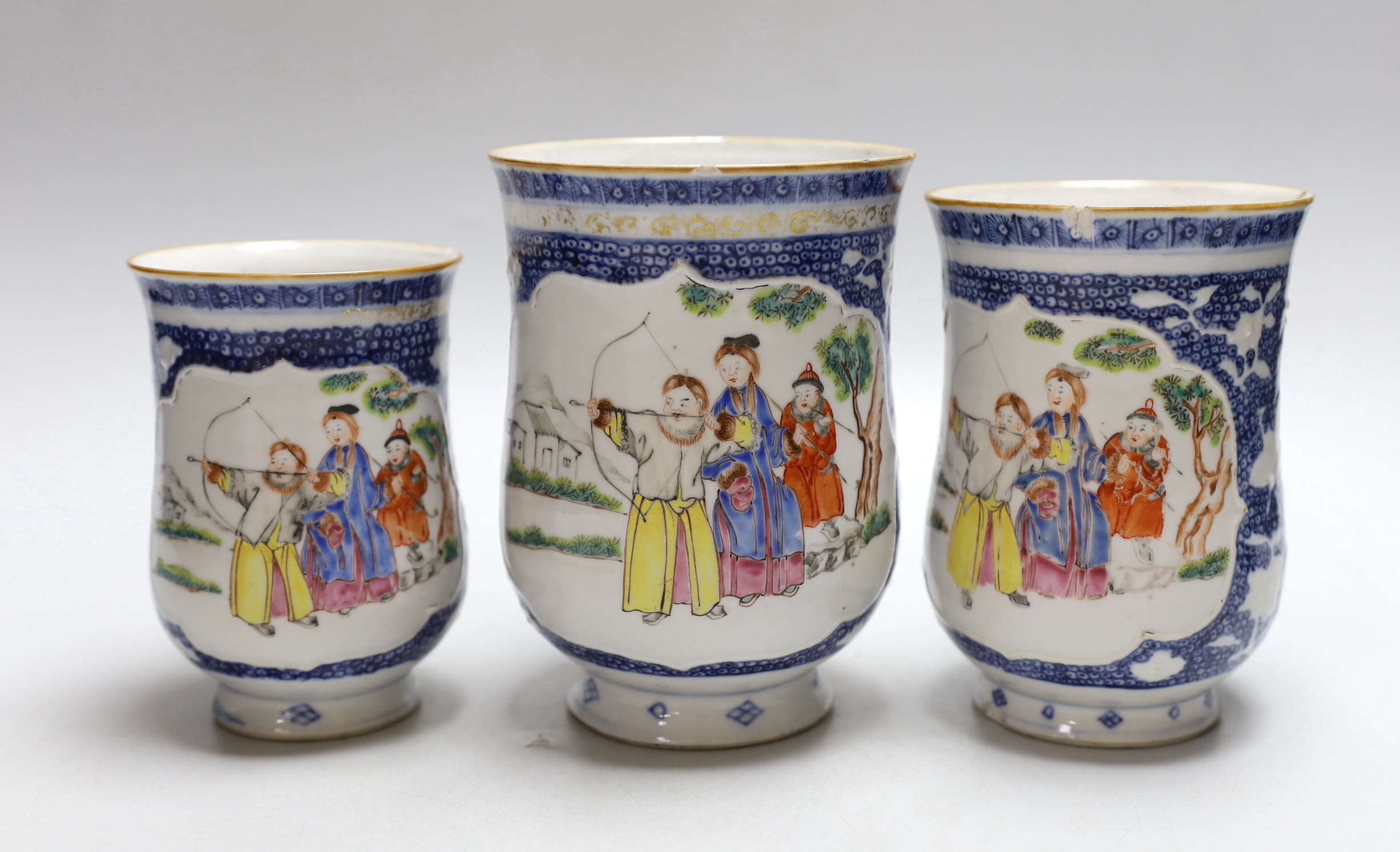 A graduated set of three Chinese mugs, Qianlong period, hand painted in the famille rose palette with figures, the largest 15cm high